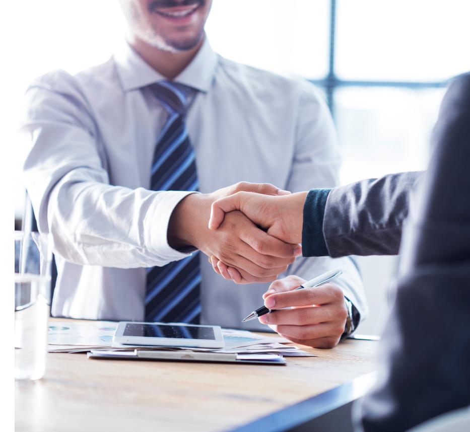 Business handshake in office setting.